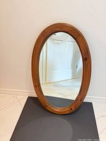 Front view showing oval wood frame and mirror glass