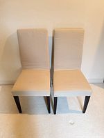 Front view of both beige upholstered chairs side by side