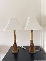 Full view of both brass and wood table lamps with shades