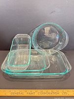 Group image showing all five Pyrex glass dishes stacked: two round pie plates, two rectangular dishes, one loaf pan