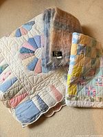 Group shot of all three textiles folded together, including Morgan’s label on throw