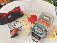 Group view of jigsaw in case, sander, tool bag, sanding sheets and discs
