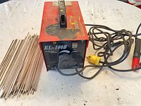 Welder with power cord, leads and electrodes