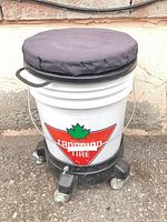 Front view of Canadian Tire bucket stool on caster base, cushion on top