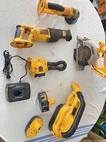 All DeWalt 18V cordless tools, charger and batteries laid out on table
