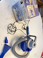 Vacuum unit with hose, DC cord, two blue nozzle attachments, retail box