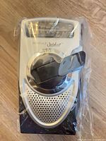 Front view of sealed Innovage Outdoor wind-up radio showing handle, speaker, and display