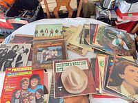 Group view of stacked and spread LP records on table showing quantity and variety