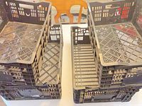 Two stacks of black plastic produce crates