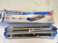 Tile cutter with box showing brand and size