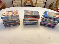 Three stacks of assorted DVD and Blu-ray cases shown on table