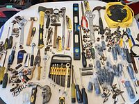 Overview of full assortment of mixed hand tools on table