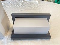 Front view of rectangular black frame sconce with white diffuser