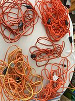 Five coiled extension cords on table