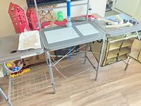 Overall view of folding camp kitchen showing sinks area, stove surface and storage shelves