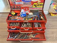 Open toolbox showing lid compartment and first drawer with mixed tools