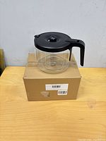 Full view of glass carafe on top of original box