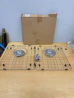 Box and two stainless sink grids with strainer and rubber feet