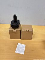 Two boxed battery adapters with one adapter displayed and instruction sheet