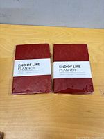 Front view of two sealed red hardcover End of Life Planners