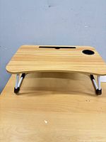 Top view showing woodgrain surface, cup holder and folded legs