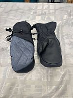 Top view of both mittens showing quilted herringbone fabric and synthetic leather palm