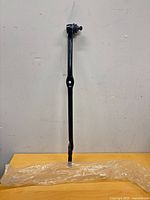 Full view of tie rod end on tabletop with plastic sleeve