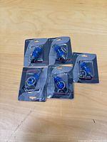 Five sealed shock absorber keychain packages laid out