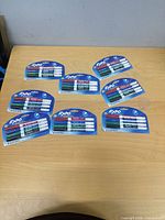 Eight sealed 4-packs of Expo dry erase markers on table