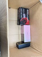 View of Evolution headset box, pink OKG box, black-gold box inside shipping box
