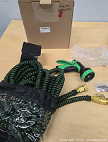 Hose, nozzle, hanger, washers and box on table