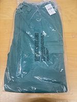 Full view of sealed package containing green cargo pants