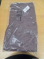 Sealed package showing folded brown pants