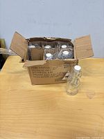 Open carton showing six bubble-wrapped glass bottles