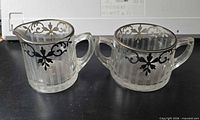 Creamer and sugar bowl front view showing ribbed glass and silver overlay
