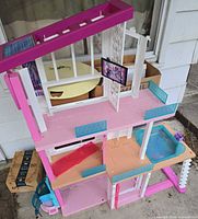 Front view of multi-level Barbie dollhouse showing overall structure and missing pieces