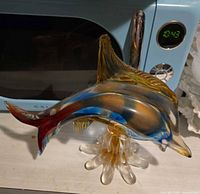 Right side view of blown glass dolphin on splash base