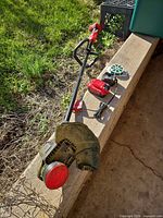String trimmer with battery, charger and line spool laid out