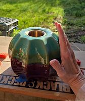 Overall view of ceramic tabletop fireplace with hand for scale