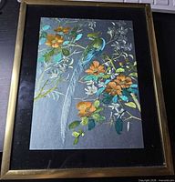 Front view of framed metal etching showing bird and flowers
