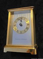 Front view showing gold-tone case, dial with Roman numerals and brand marking