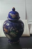 full view of ginger jar with lid showing peacock and floral painting