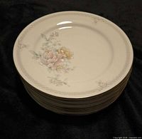 Stack of eight Noritake Easthampton dinner plates showing floral design and gold trim