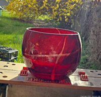 Front angled view of red blown glass bowl showing color, shape and surface condition