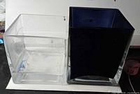 Clear and blue cube glass holders side by side