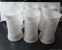 Six white milk glass steins front view showing embossed tavern scene
