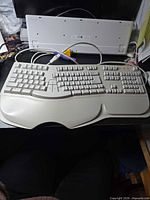 Top view of keyboard showing split layout, keys, palm rest, attached PS/2 cable