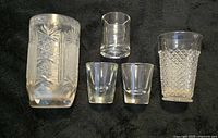 Front view of all five glassware pieces on dark background