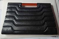 front of black textured case showing design and amber handle