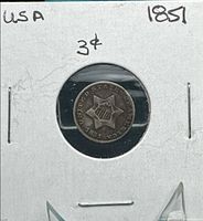 Coin in 2×2 cardboard holder showing obverse star design and date 1851
